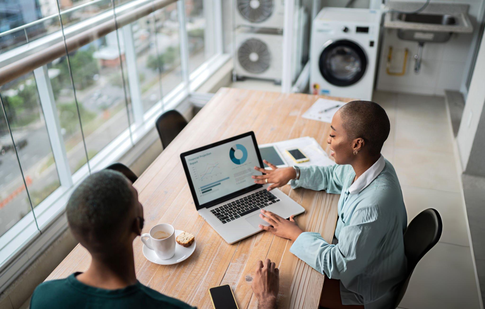 African business professionals discussing a report on a laptop